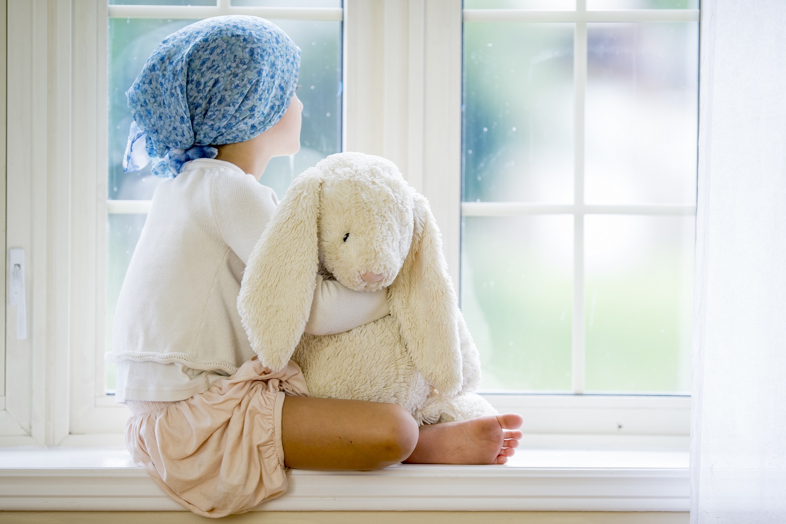 child with cancer looking out window
