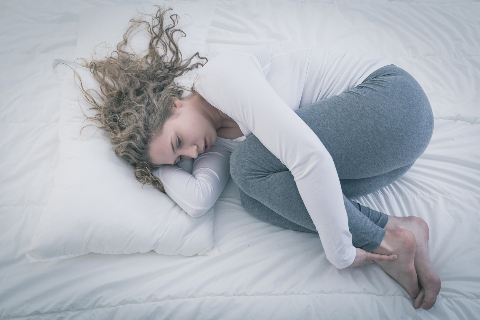 girl curled up in bed