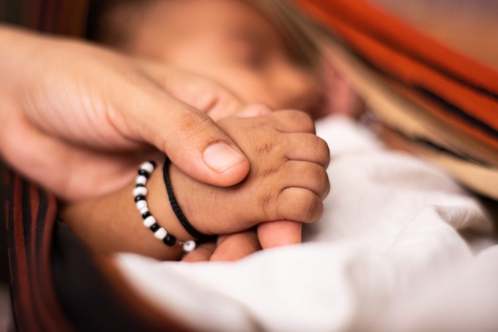 holding sleeping baby's hand