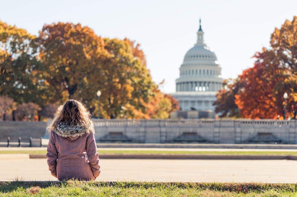 girl looking at capitol building in the fall