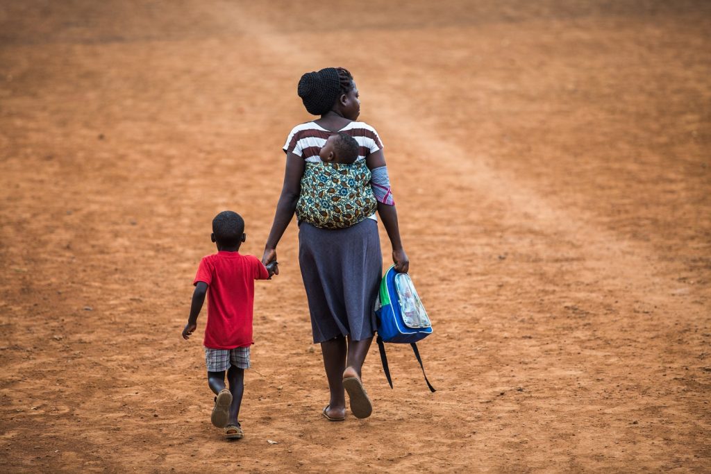 Ugandan mother walking with her children