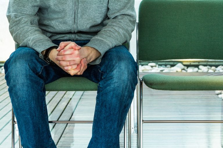 man sitting with hands folded