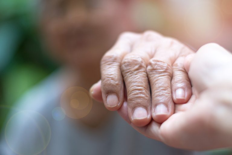 holding an elderly person's hand