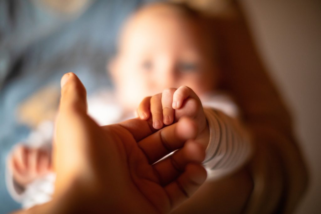 holding hand of newborn baby