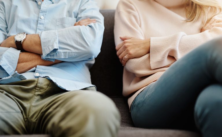 a couple sitting with their arms crossed