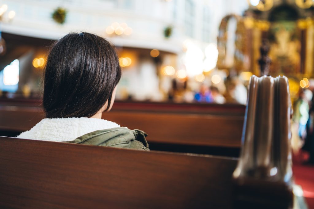 girl sitting in church pew