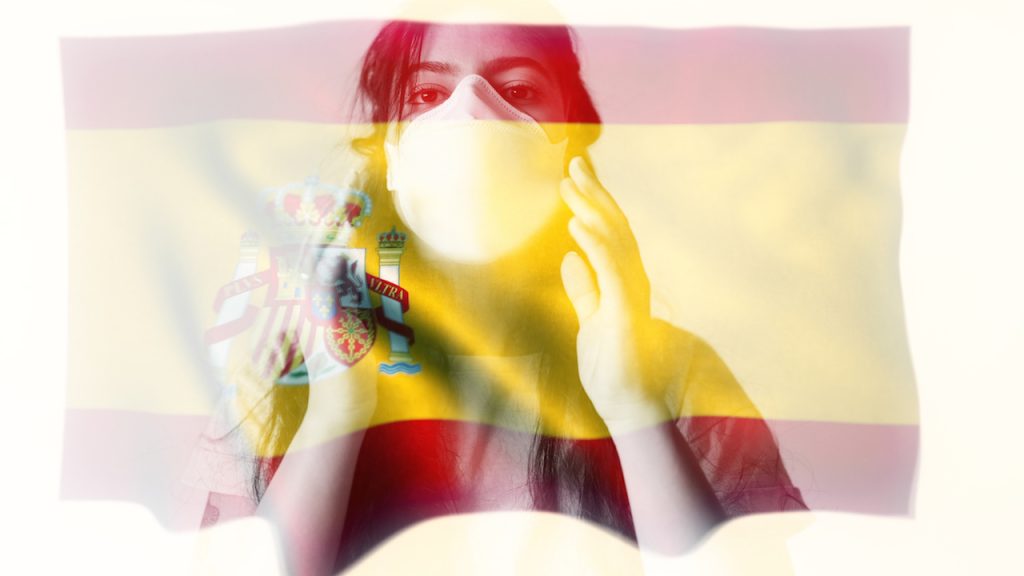 masked Spanish woman and flag
