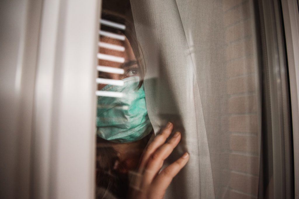 woman peeking from behind curtain