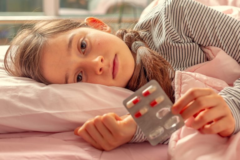 little girl holding pills